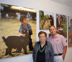 Abel Covarrubias and Antonia Covarrubias standing beside youth agriculture photos