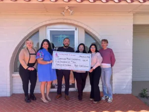 Covarrubias-Aprendamos Foundation and Luminous Mind Foundation teams holding a $500 sponsorship check